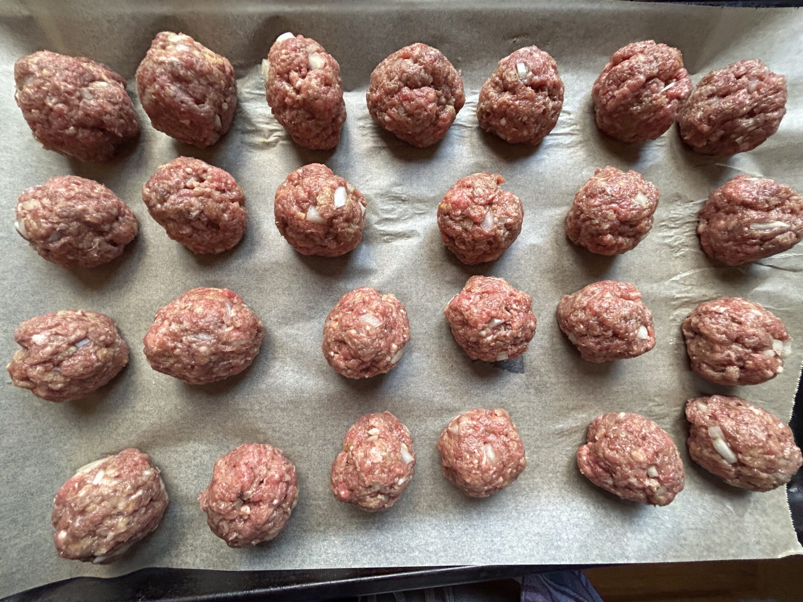 Meatballs on parchment paper lined baking sheet