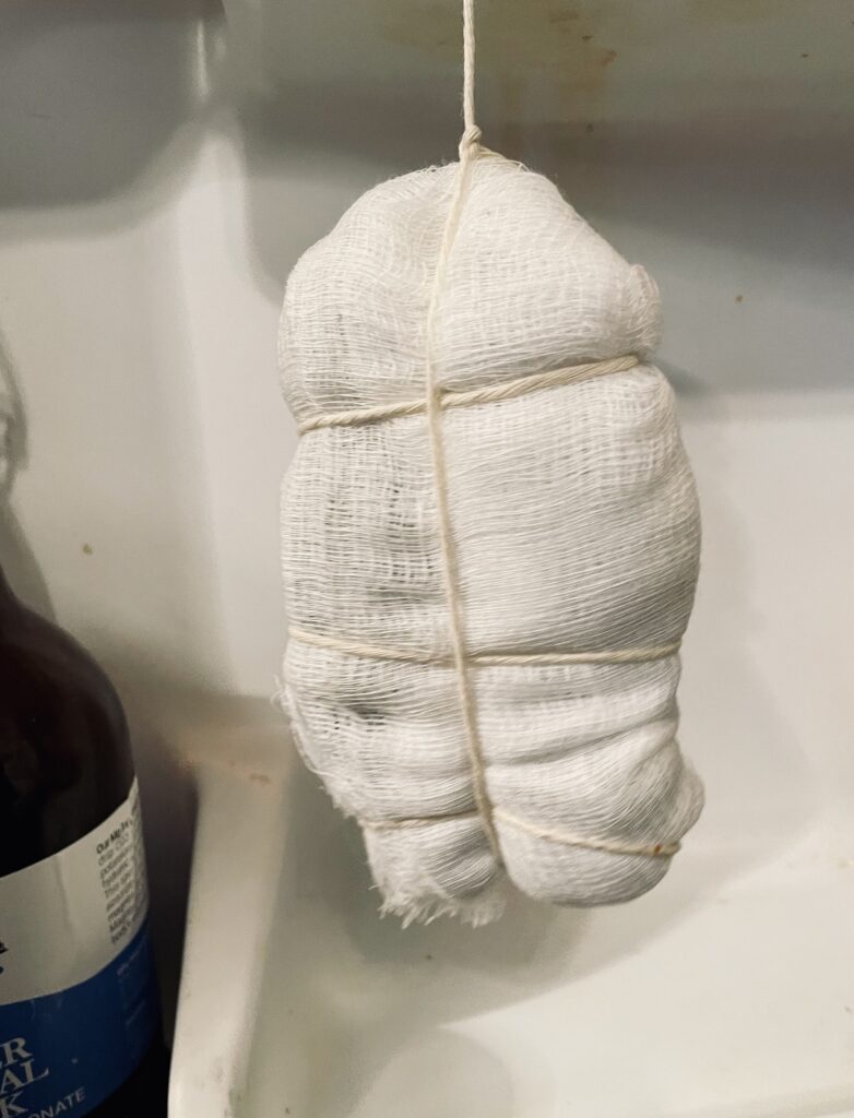 Hanging Prosciutto in fridge wrapped in cheesecloth and butchers twine