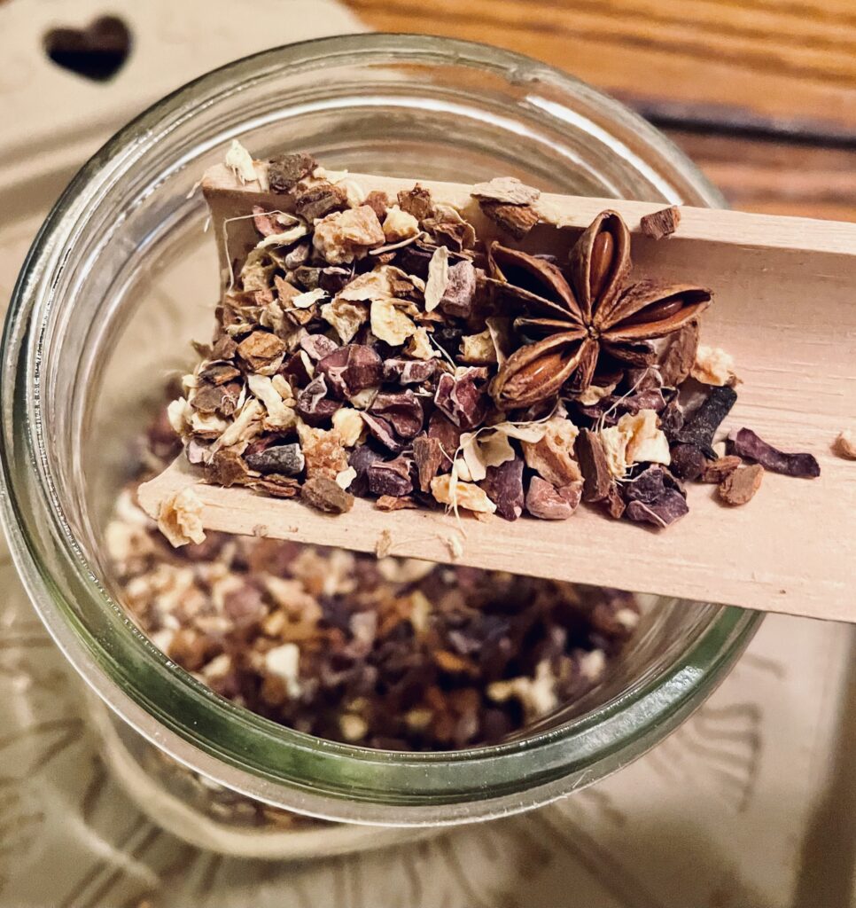 close up loose herbal tea on wooden spoon over mason jar