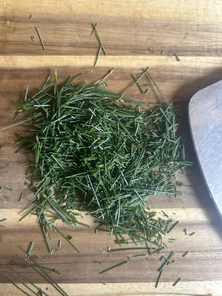 Chopped white pine needles on a cutting board.